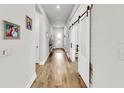 Hallway featuring wood floors, white walls, and sliding barn doors at 5317 Del Coronado Dr, Apollo Beach, FL 33572