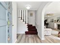 Entryway view with a staircase and arched entry to living room, displaying modern flooring at 11124 Corlett Rd, Riverview, FL 33578