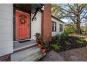 Close-up of front door, red brick chimney, landscaping, and plants at 1209 E Idlewild Ave, Tampa, FL 33604