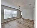 A bright living room is illuminated by a window and features new plank floors at 13506 Copper Head Dr, Riverview, FL 33569