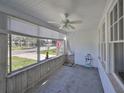 Bright sunroom with large windows, neutral tile flooring, and a ceiling fan, perfect for relaxing at 15548 1St E St, Redington Beach, FL 33708