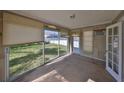 Sunroom with large windows, neutral tile flooring, and a door leading to the backyard at 15548 1St E St, Redington Beach, FL 33708