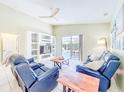 Cozy living room with tile flooring, ceiling fan and sliding glass doors to the screened-in patio and pool at 1609 Shady Oaks Dr, Oldsmar, FL 34677