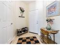 Welcoming entryway featuring a tile floor, decorative vase, wall art, and a convenient shoe rack at 18012 Melibee Stone St, Tampa, FL 33647