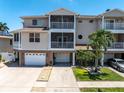 Beautiful three-story exterior featuring multiple balconies and a two-car garage at 219 126Th Ave, Treasure Island, FL 33706