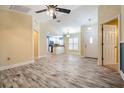 Open-concept living room features wood-look flooring, a ceiling fan, and access to kitchen at 29307 Schinnecock Hills Ln, San Antonio, FL 33576