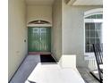 Inviting entryway featuring a green double door, covered porch, and tiled flooring at 3822 Salida Delsol Dr, Sun City Center, FL 33573