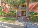 Building exterior displaying entrance and walkways surrounded by colorful garden bed and lush tropical landscaping at 4207 S Dale Mabry Hwy # 6207, Tampa, FL 33611