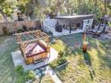 Aerial view of backyard featuring a hot tub, covered dining area, and well-maintained lawn at 472 Pine St, Tarpon Springs, FL 34689