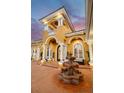 Grand front entrance with a decorative fountain and a detailed facade with columns and archways at 4873 Quill Ct, Palm Harbor, FL 34685