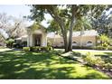 Charming single-story home with manicured lawn and landscape, featuring a columned portico entryway and arched windows at 6222 Kingbird Manor Dr, Lithia, FL 33547