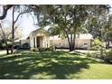 Beautiful single-story home has mature trees, a well-manicured lawn, and an elegant columned entryway at 6222 Kingbird Manor Dr, Lithia, FL 33547