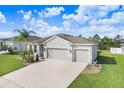 Beautiful exterior view of home showing a three car garage, lush landscaping and a paver driveway at 6307 113Th E Ter, Parrish, FL 34219