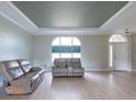 Bright living room featuring tray ceiling, modern furniture and large windows that let in plenty of light at 7056 Landover Blvd, Spring Hill, FL 34608