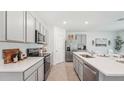 Modern kitchen featuring white countertops, stainless steel appliances, and gray cabinets at 7804 Wheat Stone Dr, Zephyrhills, FL 33540