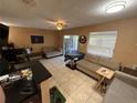 Spacious living room featuring neutral tones, tile floors, and sliding glass doors to outdoor living space at 13915 Village View Dr, Tampa, FL 33624