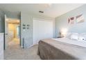 Cozy bedroom with carpeted floors, a ceiling fan, and a closet with a white bi-fold doors at 2111 Roanoke Springs Dr, Ruskin, FL 33570