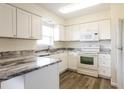 Well-equipped kitchen boasting ample counter space, white cabinets, and modern appliances at 28 Caddy Rd, Rotonda West, FL 33947