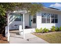 Cozy white porch with seating, decorative plants, and a view of the home's charming exterior at 4415 4Th S Ave, St Petersburg, FL 33711