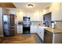 Updated kitchen featuring stainless steel appliances, white cabinets, granite countertops, and a farmhouse sink at 6307 Songbird Way, Tampa, FL 33625