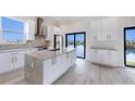 Sleek, modern kitchen with stainless steel appliances, center island, granite countertops, and a scenic water view at 777 Gran Kaymen Way, Apollo Beach, FL 33572