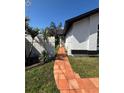 Walkway lined with lush landscaping leading to the front entrance of the house at 8706 N Boulevard, Tampa, FL 33604