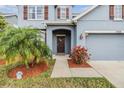 Inviting front entryway with a decorative door wreath and neat landscaping at 11938 Bahia Valley Dr, Riverview, FL 33579