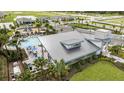 Overhead view of the community clubhouse with a pool, playground, lush landscaping, and surrounding residential area at 12316 49Th E St, Parrish, FL 34219