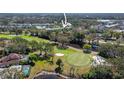 Aerial view of condo building with golf course, trees, and well-maintained landscaping at 129 W Cypress Ct, Oldsmar, FL 34677