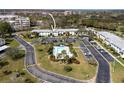 Aerial view of condo building with a pool, parking, trees, and well-maintained landscaping at 129 W Cypress Ct, Oldsmar, FL 34677