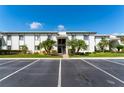 Exterior view of condo building with parking, tropical trees, and well-maintained landscaping at 129 W Cypress Ct, Oldsmar, FL 34677