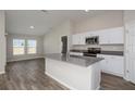 Modern kitchen featuring white cabinets, stainless steel appliances, gray counters and island with sink at 13022 Wellspring Dr, Lithia, FL 33547