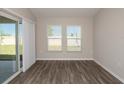 Bright living room featuring wood-look floors, natural light and sliding glass doors to covered patio at 13022 Wellspring Dr, Lithia, FL 33547