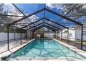 Screened-in pool boasts crystal-clear water, tiled edges, and ample space for relaxation and recreation at 13508 Greenleaf Dr, Tampa, FL 33613