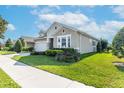 Charming one-story home featuring a well-kept lawn with landscaped flowerbeds and healthy green bushes at 14005 Kingfisher Glen Dr, Lithia, FL 33547