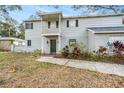 Charming two-story home with grey siding, brick accents, balcony, and a well-manicured lawn at 14803 Tulip Dr, Tampa, FL 33613