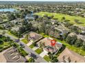 Aerial shot of a neighborhood with golf course, pond, mature trees, and well-manicured lawns at 1912 Acadia Greens Dr, Sun City Center, FL 33573