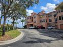 Beautiful multi-story condo building with palm trees and a glimpse of the water in the distance at 2755 Via Capri Dr # 1215, Clearwater, FL 33764