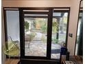 Patio view from inside the home with stone pavers and lush landscaping at 29318 Whipporwill Ln, Wesley Chapel, FL 33543