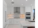 Modern kitchen featuring white cabinetry, stainless steel appliances, a mosaic backsplash, and ample counter space at 301 1St S St # 2104, St Petersburg, FL 33701