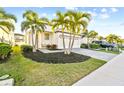 Well-maintained front yard with tropical landscaping and a brick driveway at 310 Blackrock Ln, Apollo Beach, FL 33572