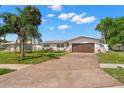 Lovely home featuring lush lawn, palm trees, a two-car garage, and charming landscaping at 4706 Shale Pl, Tampa, FL 33615