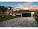 Beautiful home featuring a well-manicured lawn, mature palm trees, and paved driveway at 4930 60Th S Ave, St Petersburg, FL 33715