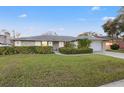 Well-maintained single-story home featuring a green lawn and beautiful landscaping at 6104 Dory Way, Tampa, FL 33615