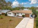 An aerial view of a single-story home with a large driveway and a well-maintained lawn at 121 Shirley Dr, Largo, FL 33770