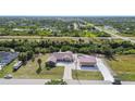 Expansive aerial view of a home with an additional storage building amid lush greenery and neighborhood at 12769 Foresman Blvd, Port Charlotte, FL 33981