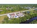 Aerial view of a house with a separate garage building, and a serene waterfront with private dock at 12769 Foresman Blvd, Port Charlotte, FL 33981