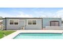 Back exterior of home with light blue painted wall and a refreshing in-ground pool at 2054 Pennsylvania Ave, Englewood, FL 34224