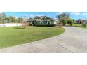 Inviting green home with a circular driveway and mature trees at 3206 Duchess Ct, Plant City, FL 33565