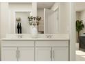 Bright bathroom featuring double sinks, white cabinets, quartz countertops, and a view of the closet at 12718 Crystal Jade Way, Parrish, FL 34219